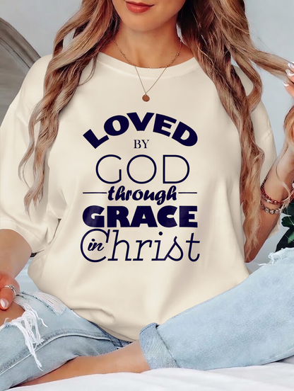 Person wearing a white t-shirt with 'LOVED BY GOD through GRACE in Christ' text.