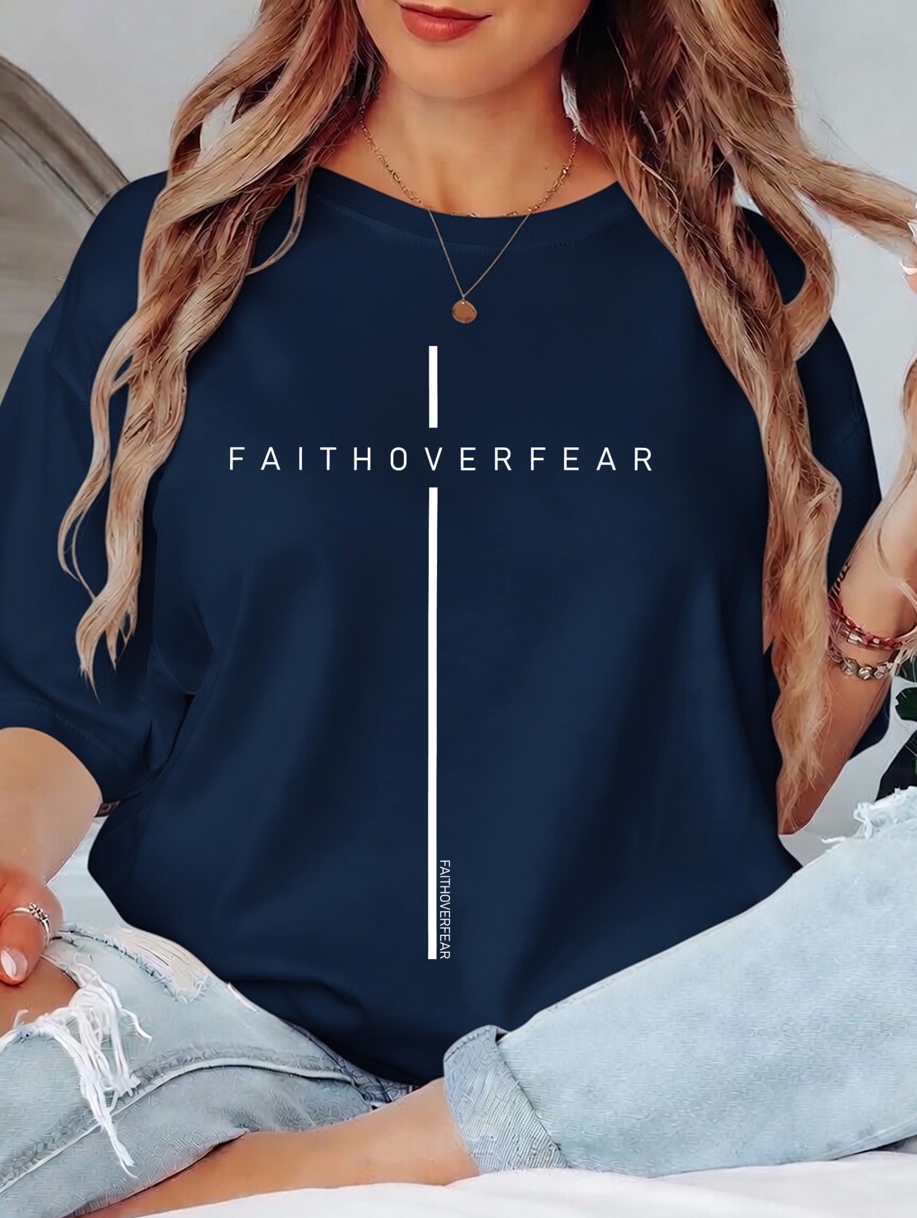 Person wearing a navy blue sweatshirt with 'FAITHOVERFEAR' text design.
