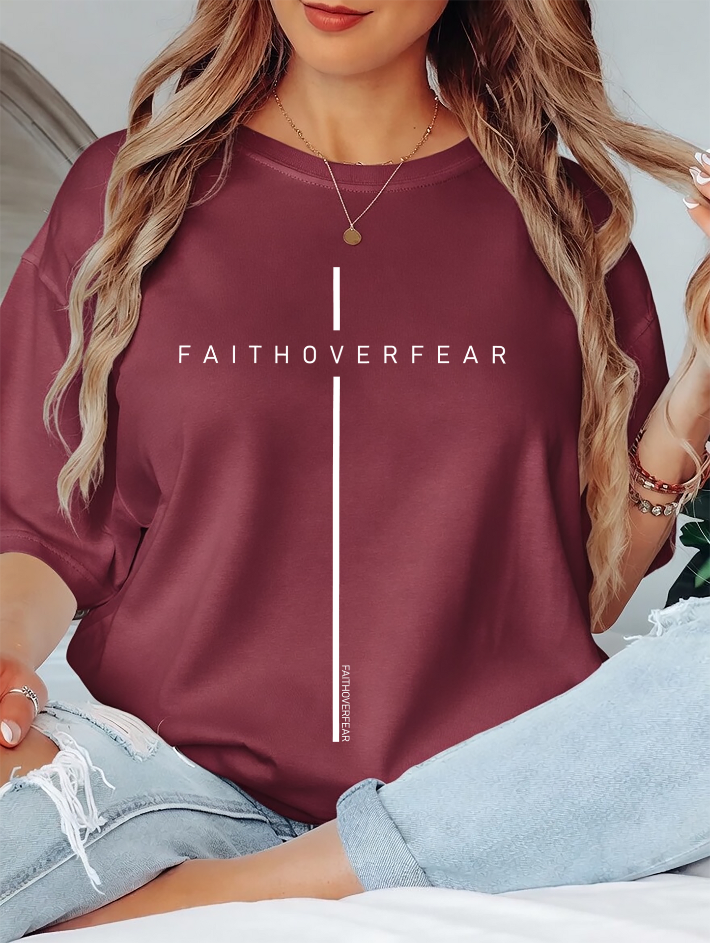 Person wearing a maroon sweatshirt with 'FAITHOVERFEAR' text