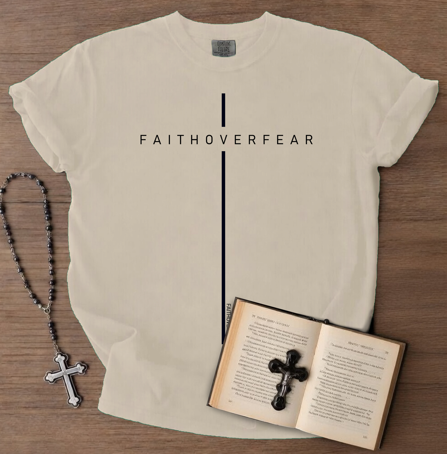 Beige t-shirt with 'FAITHOVERFEAR' text, rosary, and open book with cross on wooden surface