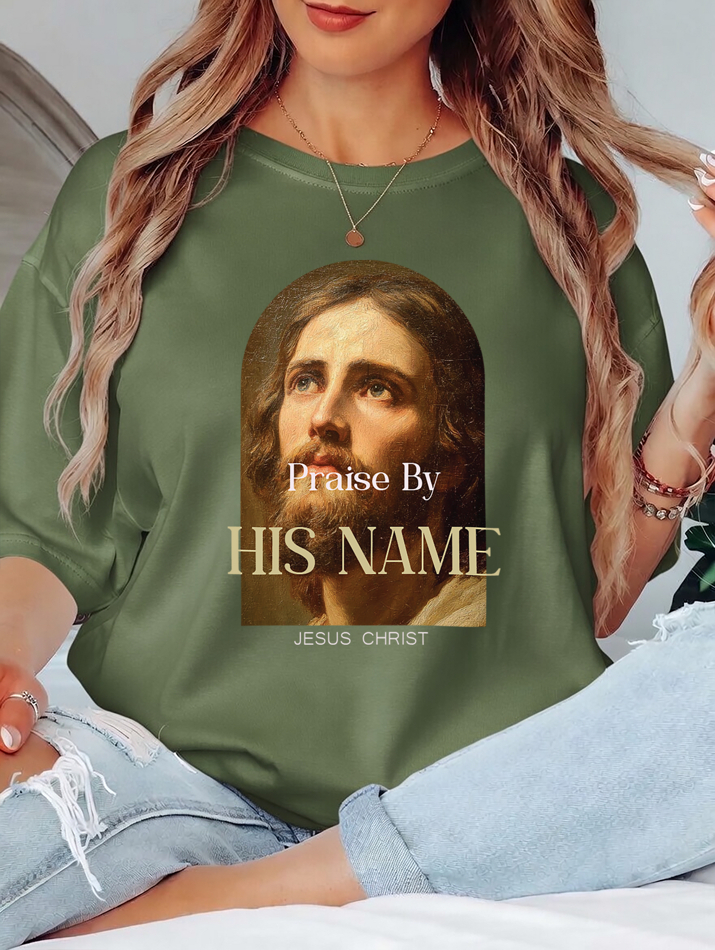 Person wearing a green shirt with a graphic of a religious figure and text.