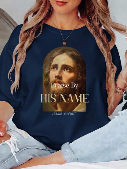 Navy blue shirt with a graphic of Jesus Christ and text 'Praise By HIS NAME JESUS CHRIST' worn by a person.