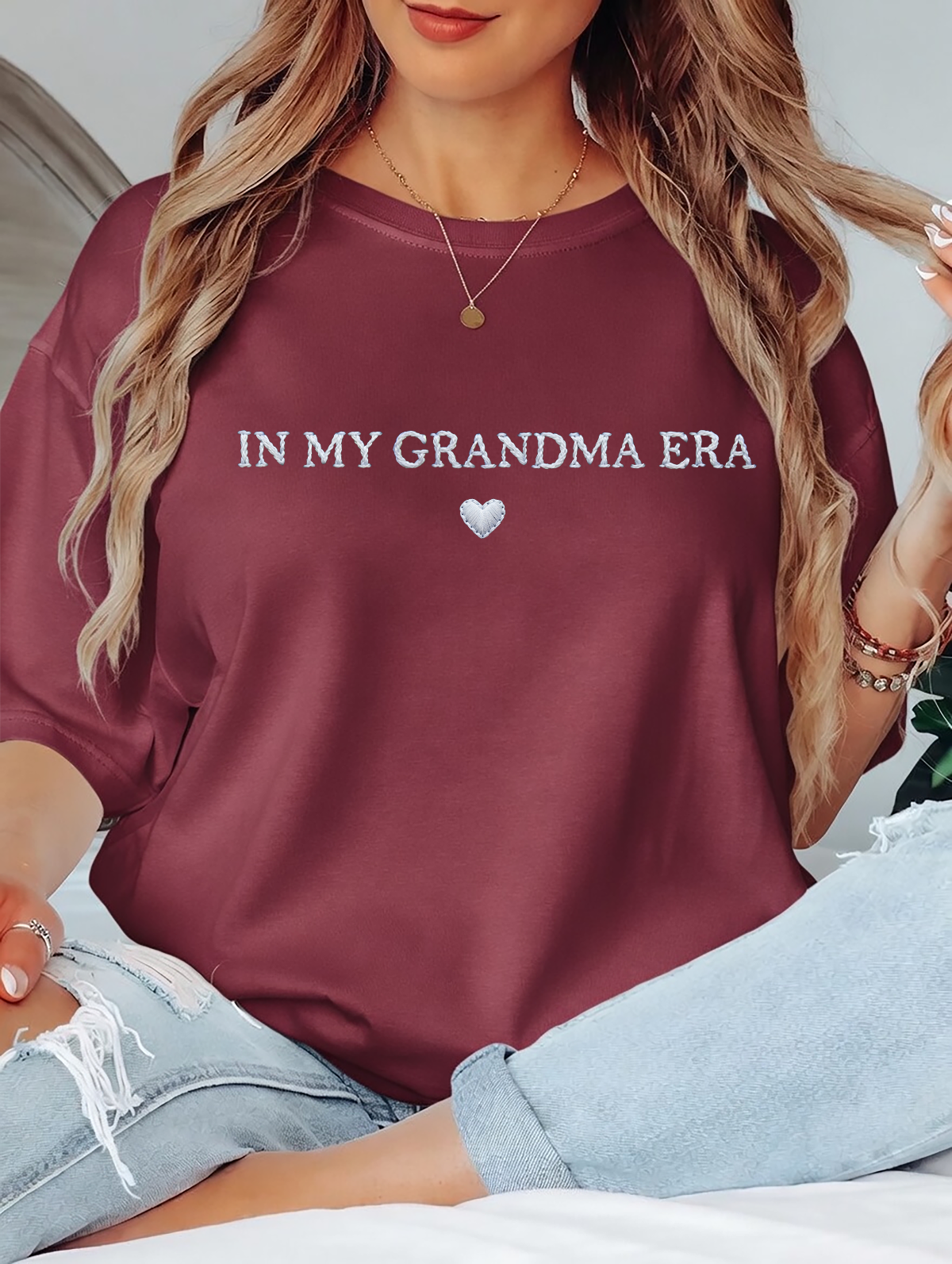 Person wearing a maroon sweatshirt with 'IN MY GRANDMA ERA' text and a heart symbol.